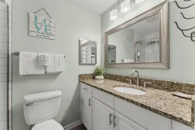 a bathroom with a toilet and a sink and a mirror at Solitude on 30A - Seacrest Beach - Beach Access in Rosemary Beach