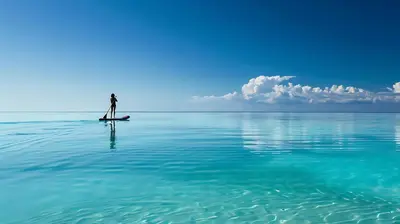 a person standing on a paddle board in the water at Seas The Day in Rosemary Beach