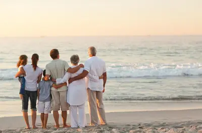 a family standing on the beach looking at the ocean at Seas The Day in Rosemary Beach