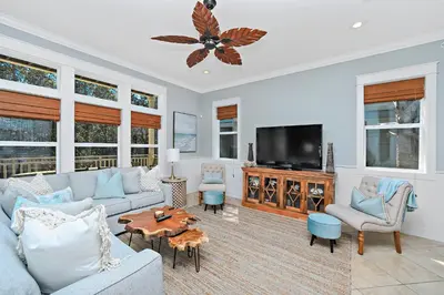 a living room with a couch and a tv at Pool's Paradise in Rosemary Beach
