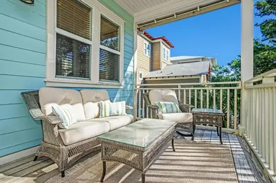 a porch with a couch and chairs on a house at Pool's Paradise in Rosemary Beach