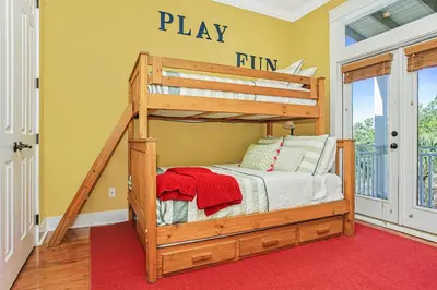 a bunk bed in a room with a red carpet at Pool's Paradise in Rosemary Beach