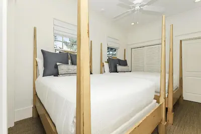 two beds in a room with two windows at Barefoot at the Beach in Watersound Beach