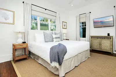 a bedroom with a large white bed and a window at Barefoot at the Beach in Watersound Beach