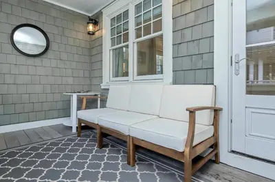 a porch with a white bench and a window at Barefoot at the Beach in Watersound Beach