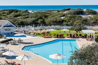 a view of a pool with umbrellas and the ocean at Barefoot at the Beach in Watersound Beach