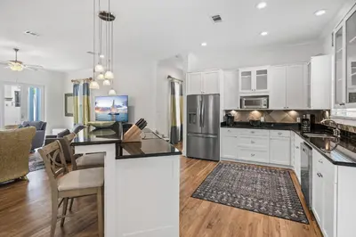 a kitchen with white cabinets and a dining room at My Blue Heaven in Rosemary Beach