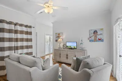 a living room with two chairs and a ceiling fan at My Blue Heaven in Rosemary Beach