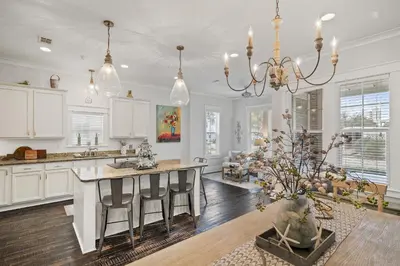 a kitchen with white cabinets and a kitchen island with chairs at Sunny Day in Seagrove Beach