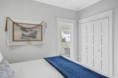 a bedroom with a white door and a blue blanket on a bed at Sunny Day in Seagrove Beach