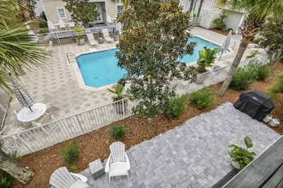 an overhead view of a swimming pool with chairs and a table at Sunny Day in Seagrove Beach