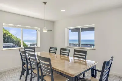 a dining room with a table and chairs and the ocean at Ashore Thing in Inlet Beach