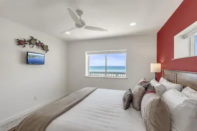 a bedroom with a bed with a red wall at Ashore Thing in Inlet Beach
