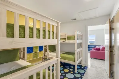 a room with bunk beds and a living room at Ashore Thing in Inlet Beach