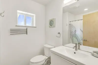 a white bathroom with a toilet and a sink at Ashore Thing in Inlet Beach