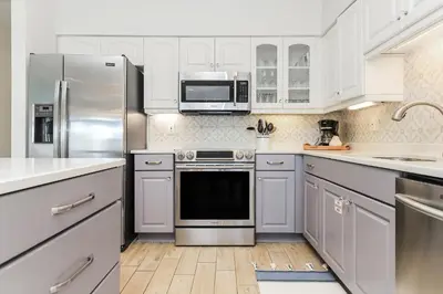 a kitchen with white cabinets and stainless steel appliances at B402 Sunset Beach Villa in Inlet Beach