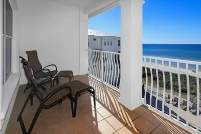 a balcony with two chairs and a view of the ocean at B402 Sunset Beach Villa in Inlet Beach