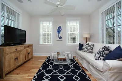 a living room with a white couch and a flat screen tv at Southern Charm in Santa Rosa Beach