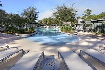 a swimming pool at a resort with chairs and trees at Southern Charm in Santa Rosa Beach