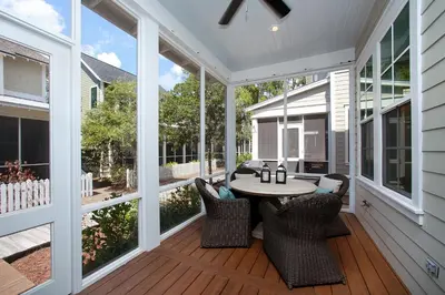 a screened porch with a table and chairs at Southern Charm in Santa Rosa Beach