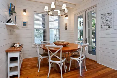 a dining room with a wooden table and chairs at Pura Vida in Watersound Beach