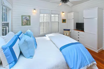 a blue and white bedroom with a bed with blue pillows at Pura Vida in Watersound Beach
