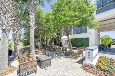 a patio with benches and tables and trees at WaterHouse 401 in Seacrest