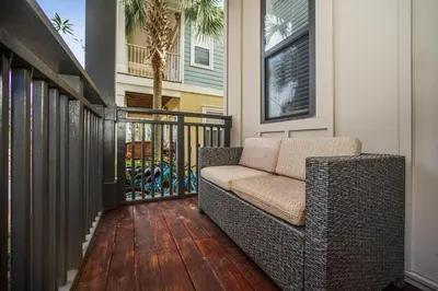 a porch with a couch on a wooden deck at Sip N' Sea in Seacrest