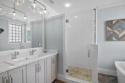 a white bathroom with a sink and a shower at Sip N' Sea in Seacrest
