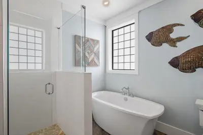 a white bathroom with a tub and a sink at Sip N' Sea in Seacrest