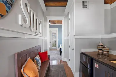 a living room with a couch and a hallway at Sip N' Sea in Seacrest
