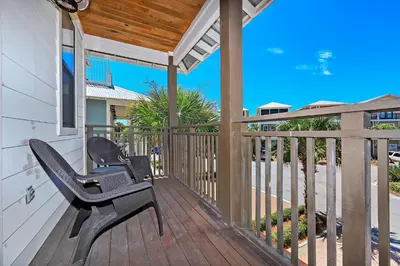 a deck with two chairs and a pergola at Sip N' Sea in Seacrest