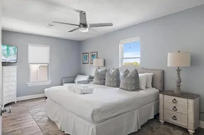 a bedroom with a large bed with a ceiling fan at Caribbean Breeze in Seacrest