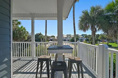 a patio with two stools and a table on a porch at Caribbean Breeze in Seacrest