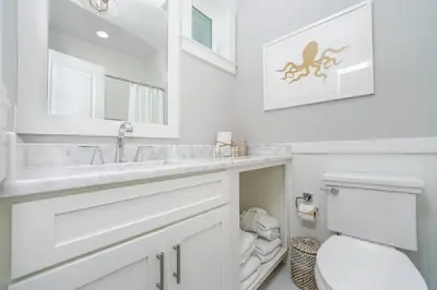 a white bathroom with a sink and a toilet at 110 Surfer Lane in Inlet Beach