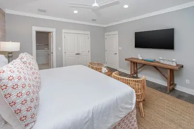 a bedroom with a bed and a flat screen tv at 110 Surfer Lane in Inlet Beach