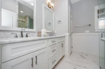 a white bathroom with two sinks and a shower at 110 Surfer Lane in Inlet Beach