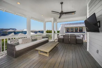 a screened in porch with a couch and a tv at 110 Surfer Lane in Inlet Beach