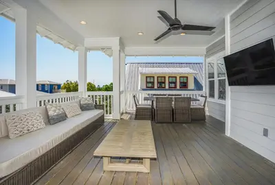 a screened in porch with a couch and a table at 110 Surfer Lane in Inlet Beach