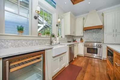 a kitchen with white cabinets and a sink at Hidden Cypress in Santa Rosa Beach