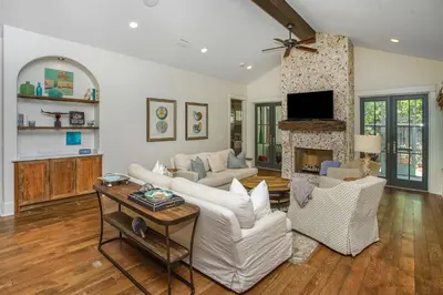 a living room with white furniture and a fireplace at Hidden Cypress in Santa Rosa Beach