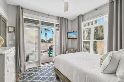 a bedroom with a bed and sliding glass doors at Edge of the Sea in Seacrest