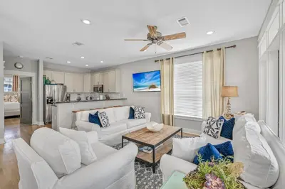 a living room with white furniture and a ceiling fan at Edge of the Sea in Seacrest