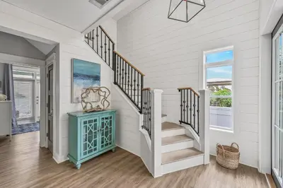a staircase in a home with white walls and wooden floors at Edge of the Sea in Seacrest