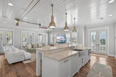 a kitchen with white cabinets and a living room at 13 Madaket Way in Watersound Beach
