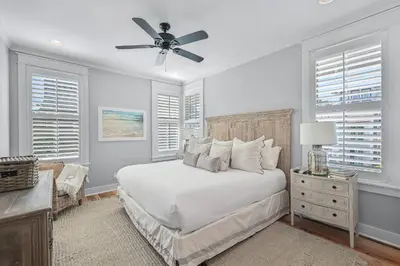a white bedroom with a bed and a ceiling fan at 13 Madaket Way in Watersound Beach