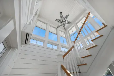 a white staircase in a home with a vaulted ceiling at 13 Madaket Way in Watersound Beach