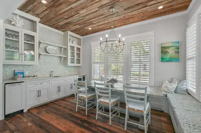 a kitchen with white cabinets and a table with chairs at 13 Madaket Way in Watersound Beach