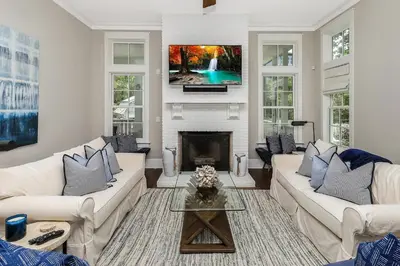 a living room with two white couches and a fireplace at 172 A Street in Inlet Beach