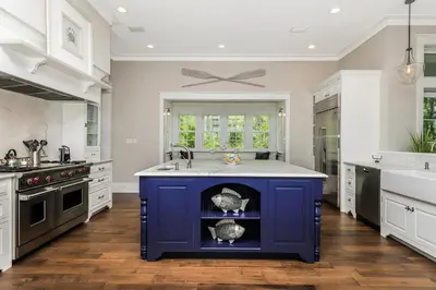a large kitchen with a blue island in the middle at 172 A Street in Inlet Beach
